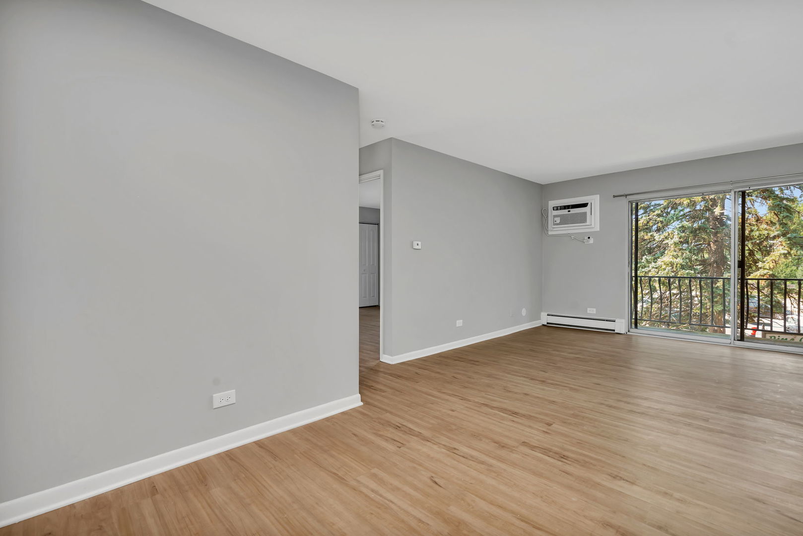 909 Plainfield Road, Unit 12 Darien, IL 60561 - Photo 6 of 10 a view of an empty room with wooden floor and a window