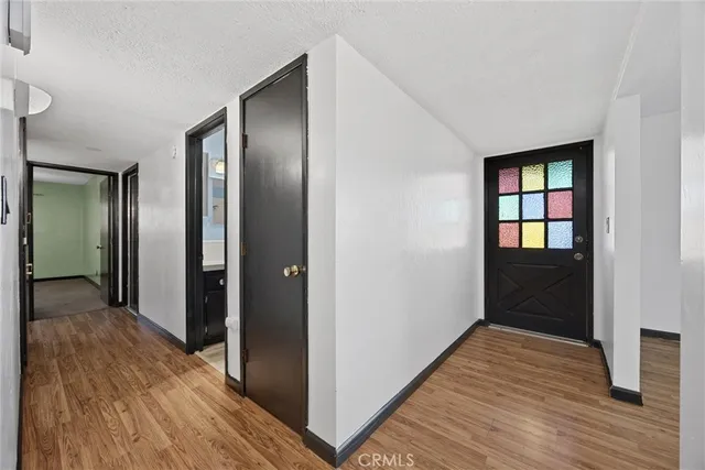 a view of a hallway with wooden floor and closet