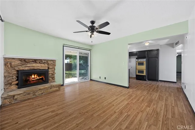 a view of an empty room with a fireplace and a window