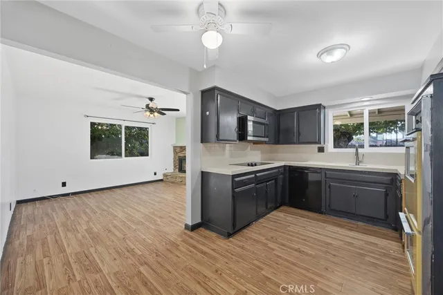 a kitchen with stainless steel appliances kitchen island granite countertop a sink stove and wooden floor