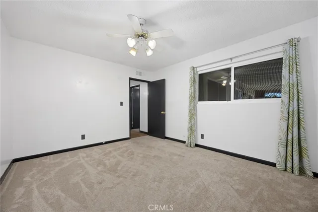a view of an empty room with a chandelier fan