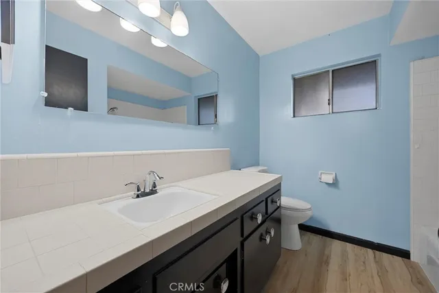 a bathroom with a sink a light fixture and a toilet