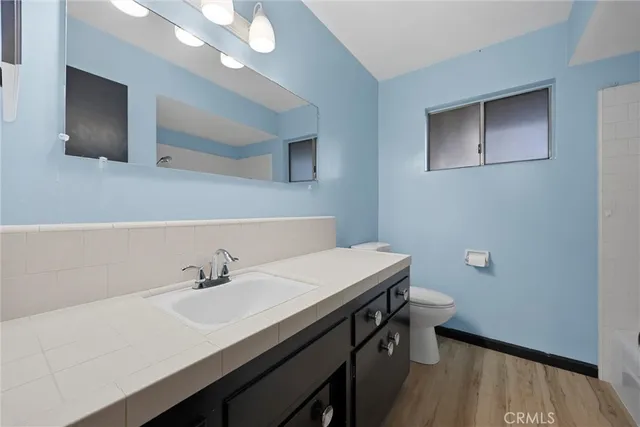 a bathroom with a sink a light fixture and a toilet