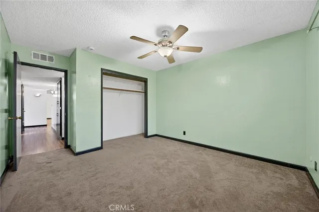 an empty room with closet and fan