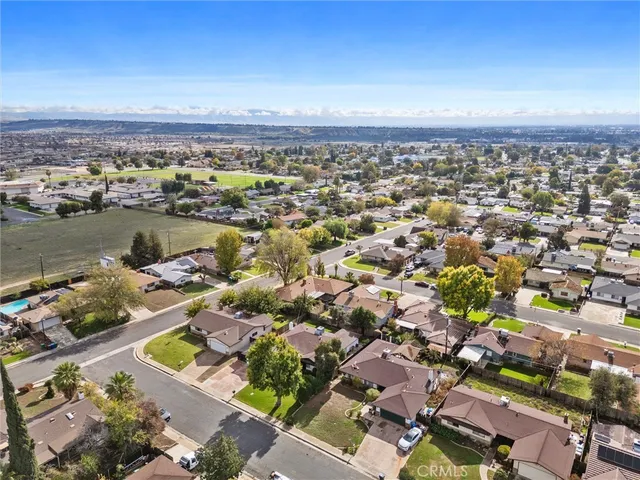 an aerial view of a city with lots of residential buildings and ocean view in back
