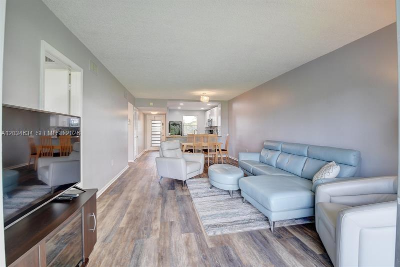 9880 Marina Boulevard, Unit 1516 Boca Raton, FL 33428 - Photo 8 of 32 a living room with furniture and a wooden floor