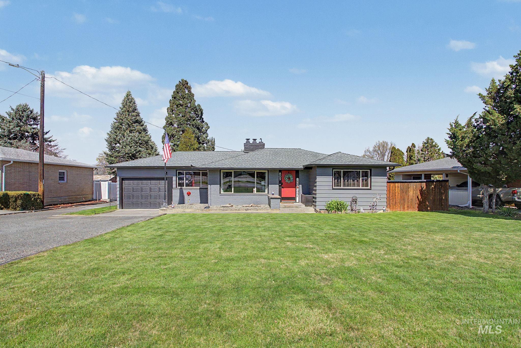 Ranch-style house featuring asphalt driveway, an attached garage, a chimney, and roof with shingles