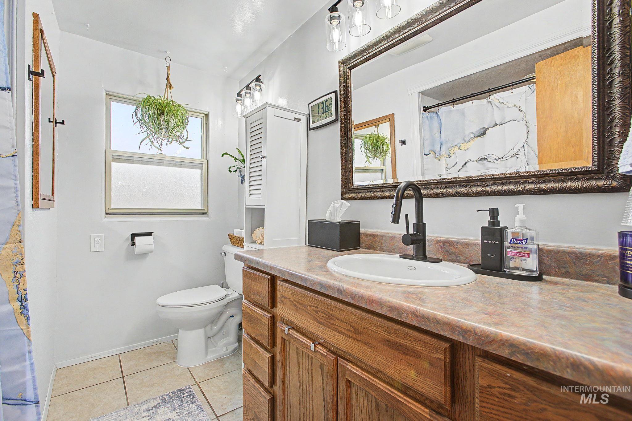 809 Bryden Avenue Lewiston, ID 83501 - Photo 17 of 42 Full bath featuring vanity, a shower with shower curtain, and light tile patterned floors