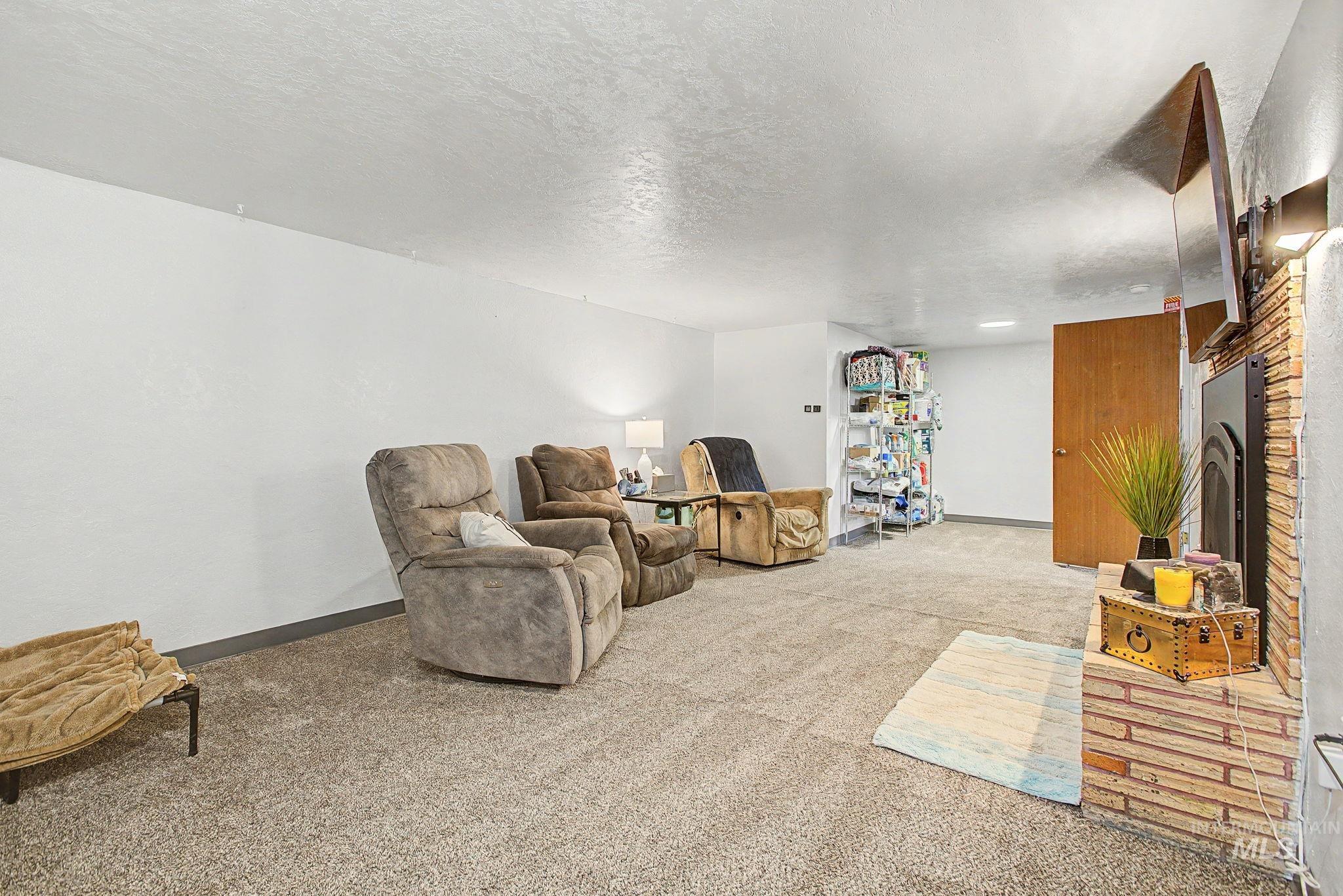809 Bryden Avenue Lewiston, ID 83501 - Photo 21 of 42 Sitting room featuring carpet floors, a textured ceiling, and a fireplace
