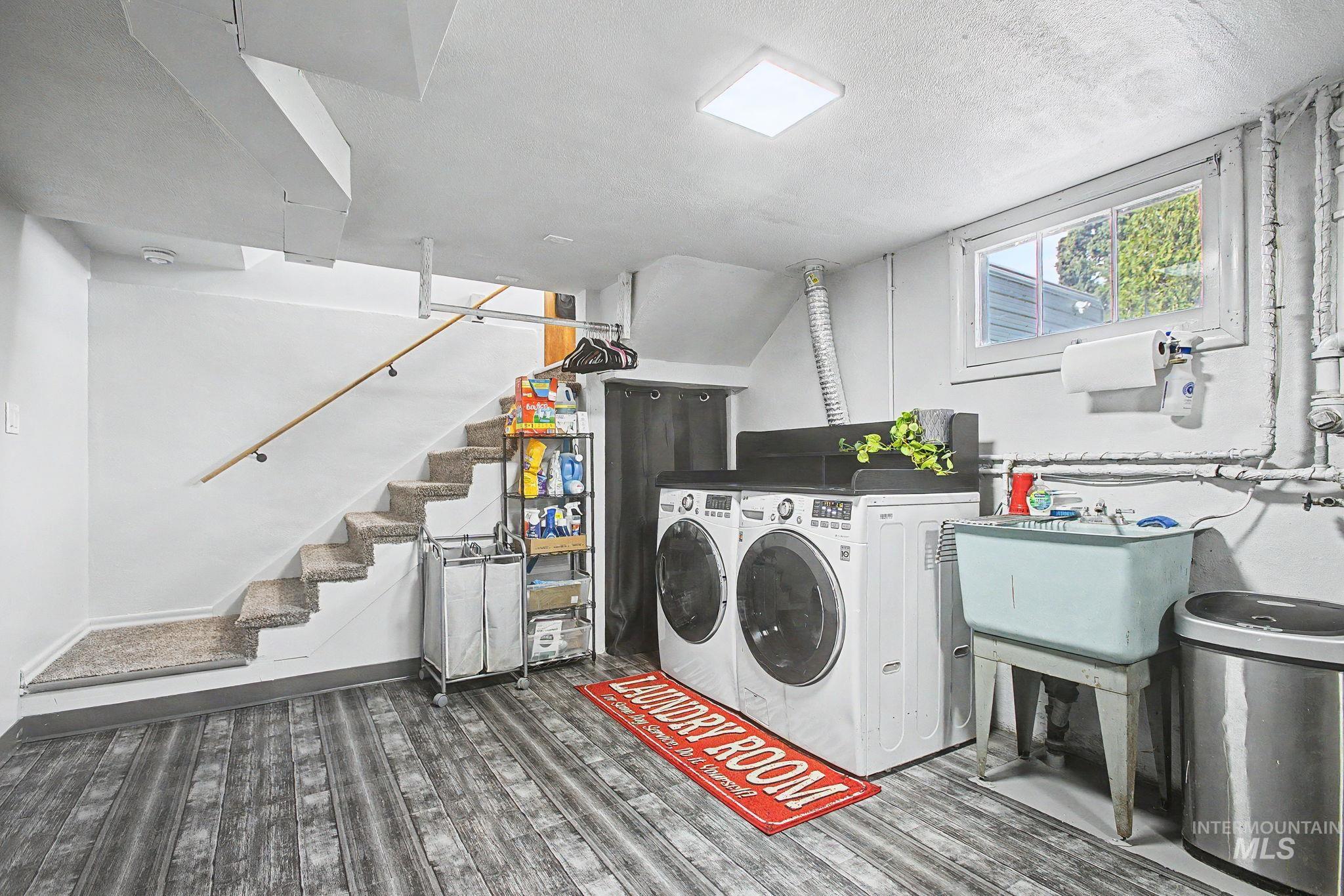 809 Bryden Avenue Lewiston, ID 83501 - Photo 26 of 42 Laundry area with dark wood-style flooring, washer and clothes dryer, and a textured ceiling