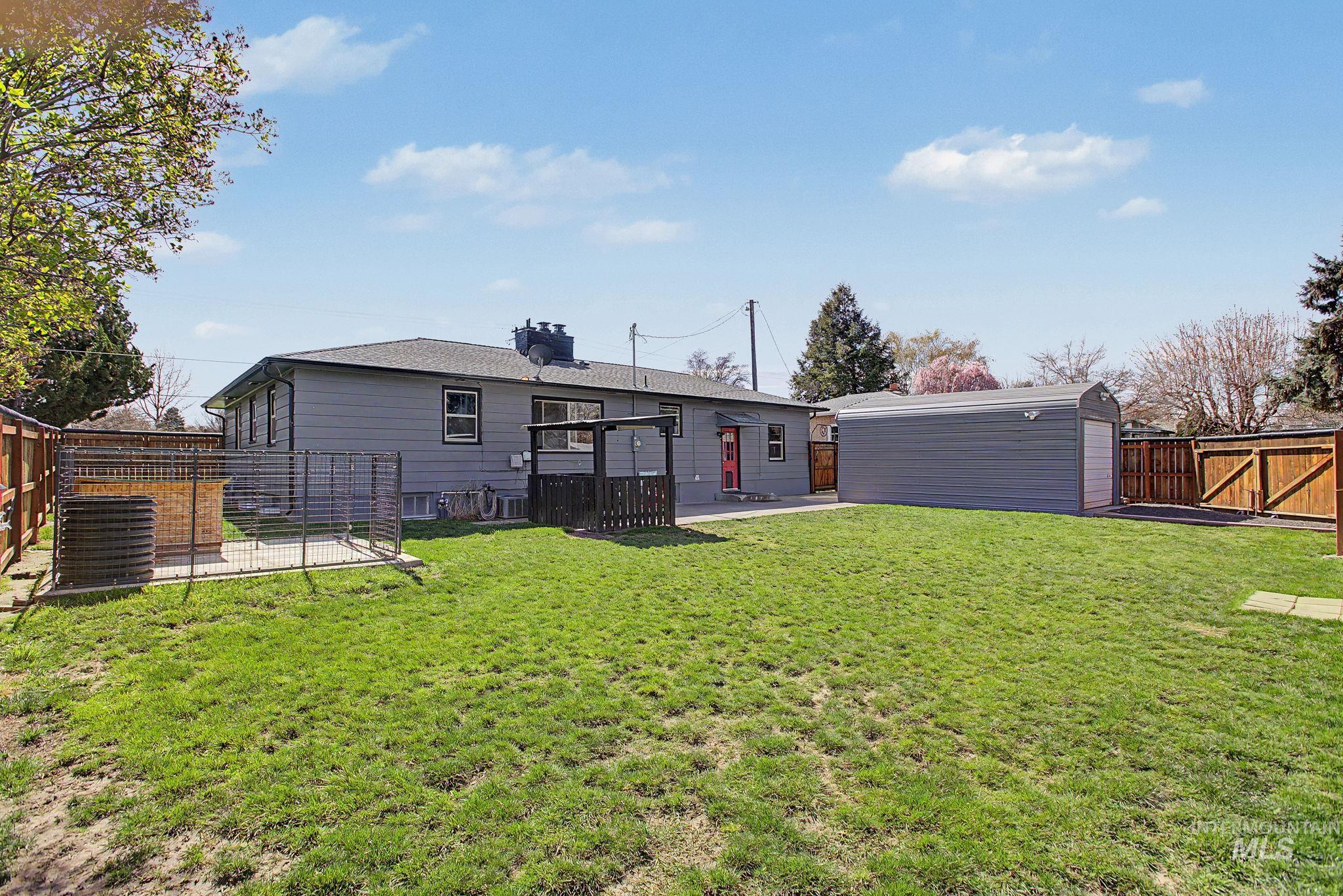 809 Bryden Avenue Lewiston, ID 83501 - Photo 33 of 42 Back of property featuring a fenced backyard, a gate, a patio, an outbuilding, and a chimney
