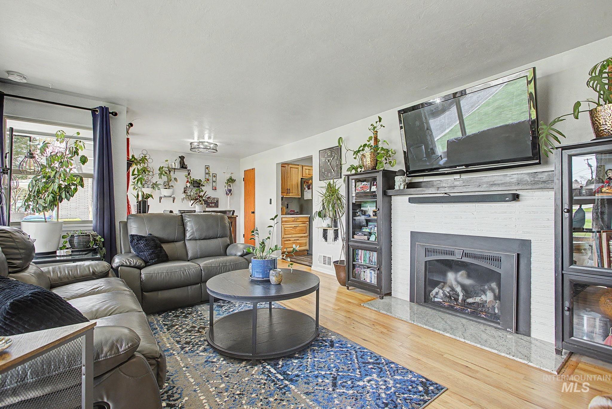 809 Bryden Avenue Lewiston, ID 83501 - Photo 5 of 42 Living room with light wood-style floors and a glass covered fireplace