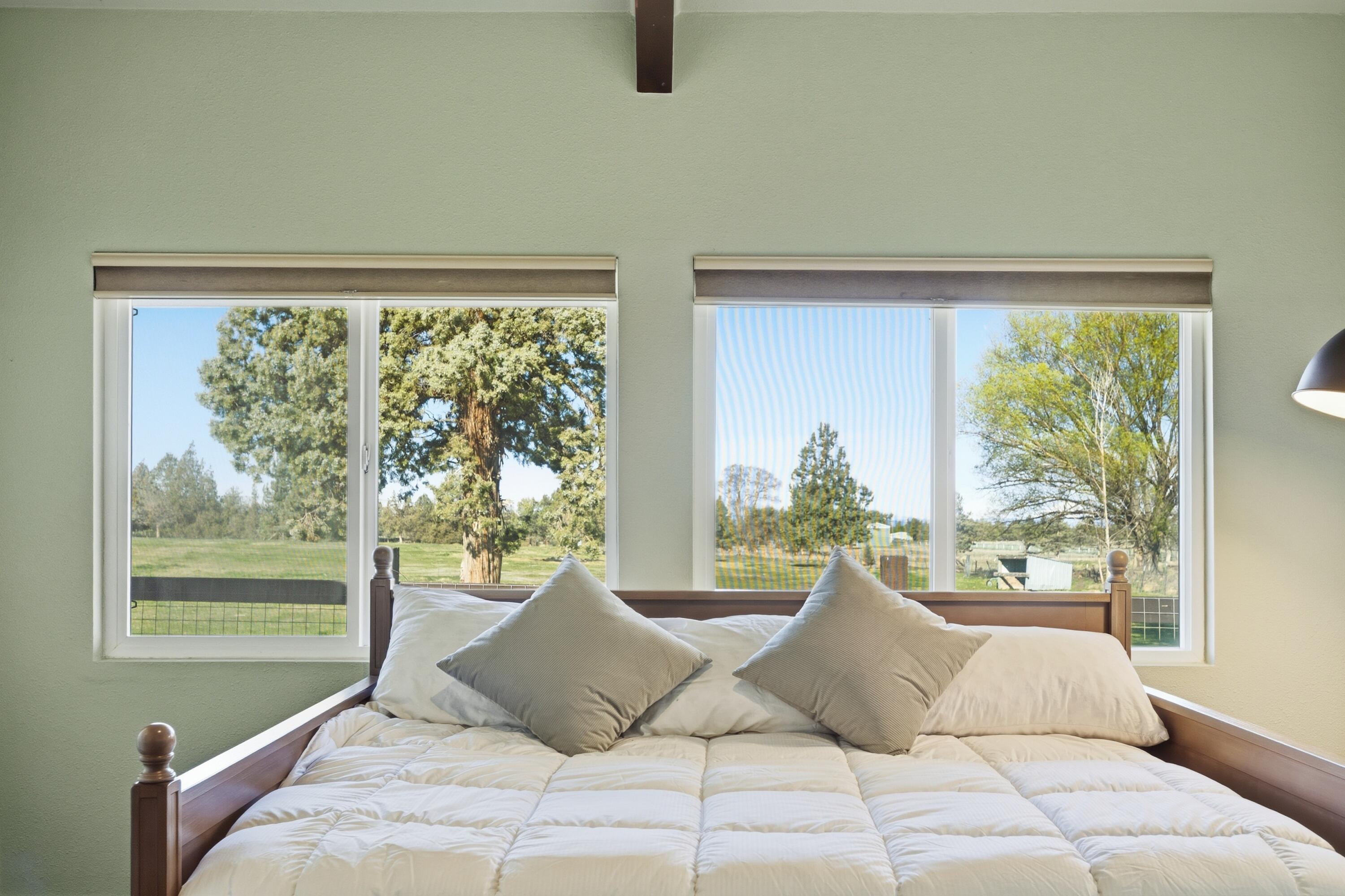 4074 Southwest Reif Road Powell Butte, OR 97753 - Photo 21 of 59 a bedroom with a bed and glass window