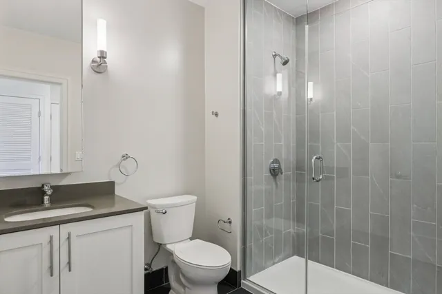 a bathroom with a granite countertop sink toilet and shower
