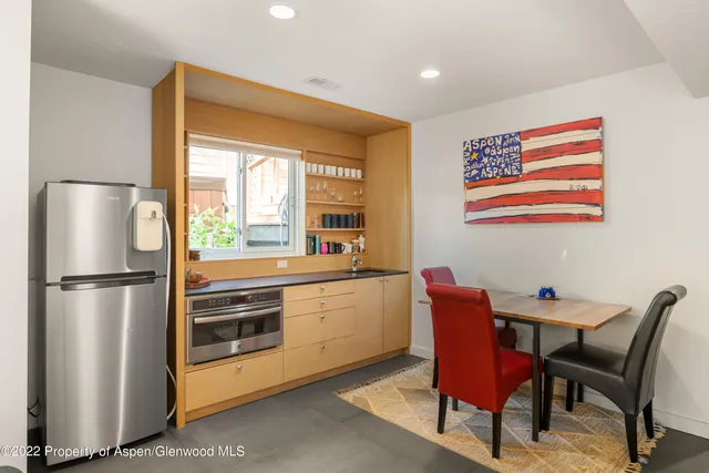 a kitchen with a refrigerator a table and chairs