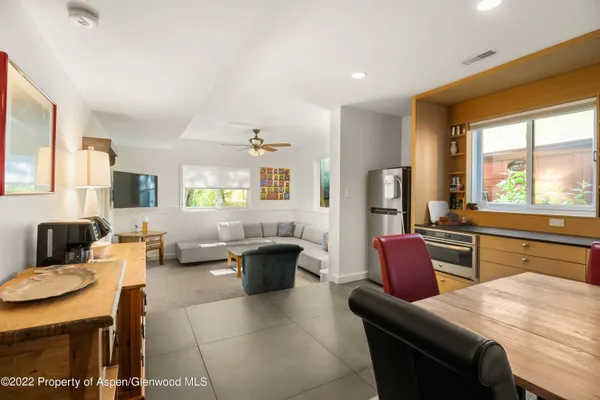 a living room with furniture a large window with kitchen view