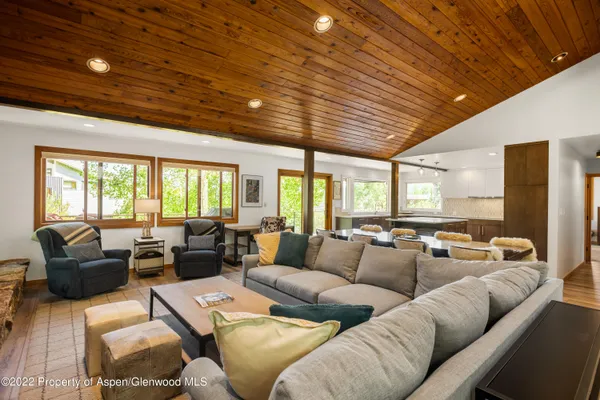 a living room with furniture ceiling fan and a large window