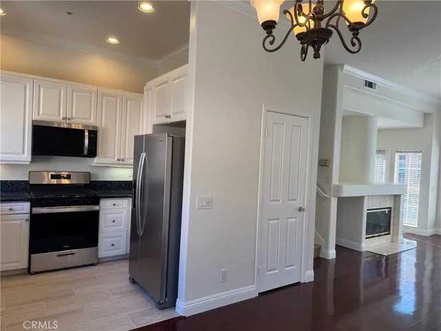 a kitchen with stainless steel appliances granite countertop a refrigerator and a stove top oven