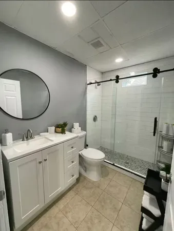 a bathroom with a toilet sink double vanity and mirror