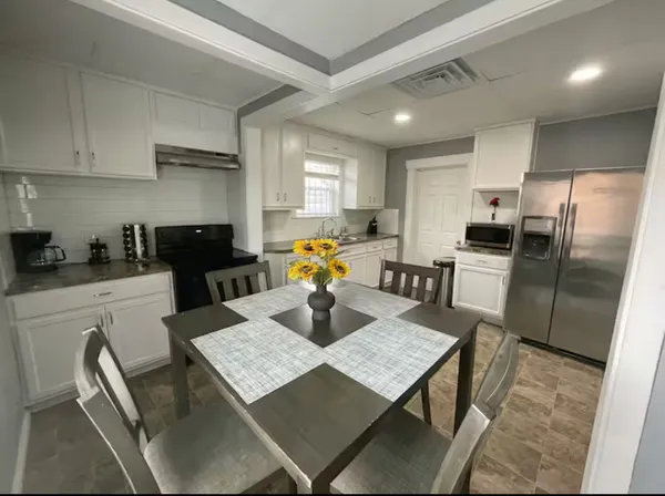 a kitchen with stainless steel appliances granite countertop sink stove refrigerator and cabinets
