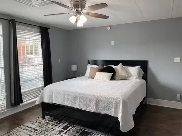 a bedroom with bed and wooden floor