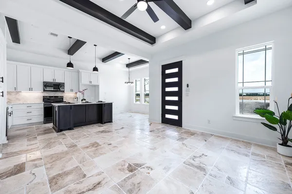 a large kitchen with stainless steel appliances kitchen island granite countertop a refrigerator and a stove top oven