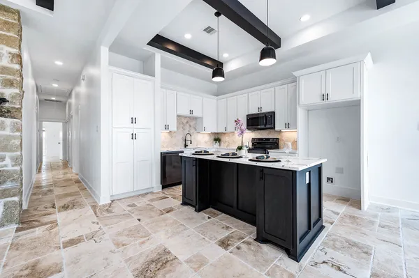 a kitchen with stainless steel appliances kitchen island granite countertop a refrigerator and a stove top oven