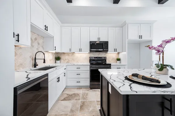a kitchen with kitchen island granite countertop a sink stove and cabinets