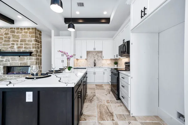 a kitchen with stainless steel appliances kitchen island granite countertop a refrigerator and a stove top oven