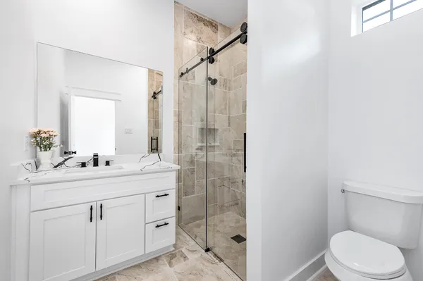 a bathroom with a sink toilet vanity and shower