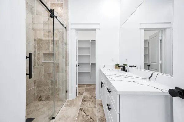 a bathroom with a double vanity sink mirror and shower