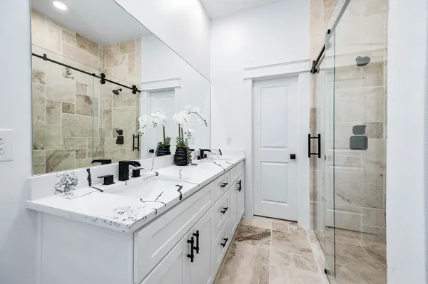 a bathroom with a sink double vanity and shower
