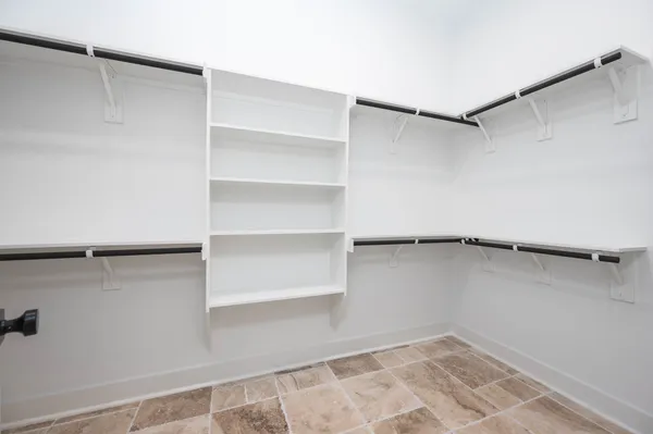 a view of walk in closet with empty racks