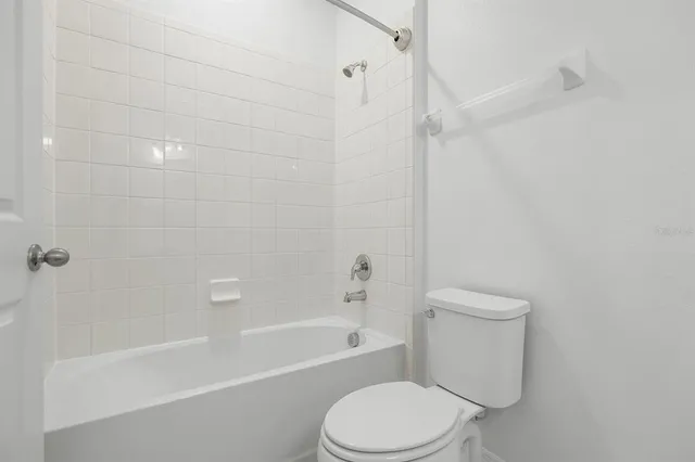 a white toilet and tub sitting next to a bathroom sink