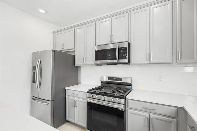 a kitchen with stainless steel appliances white cabinets and a stove