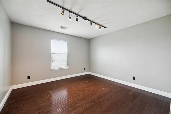 a view of a big room with wooden floor and windows
