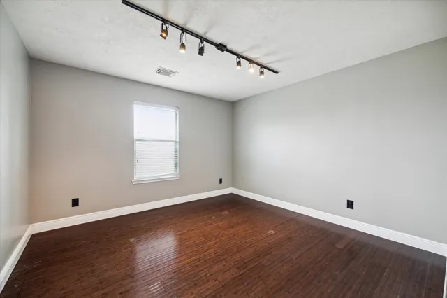 a view of a big room with wooden floor and windows