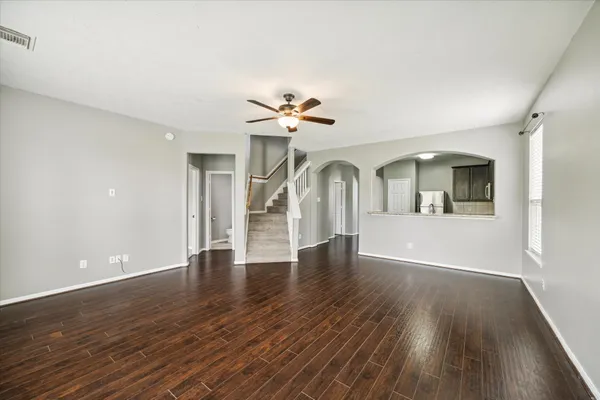 a view of an empty room with a window and wooden floor