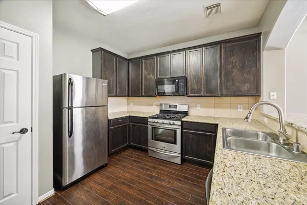 a kitchen with wooden cabinets stainless steel appliances and a sink