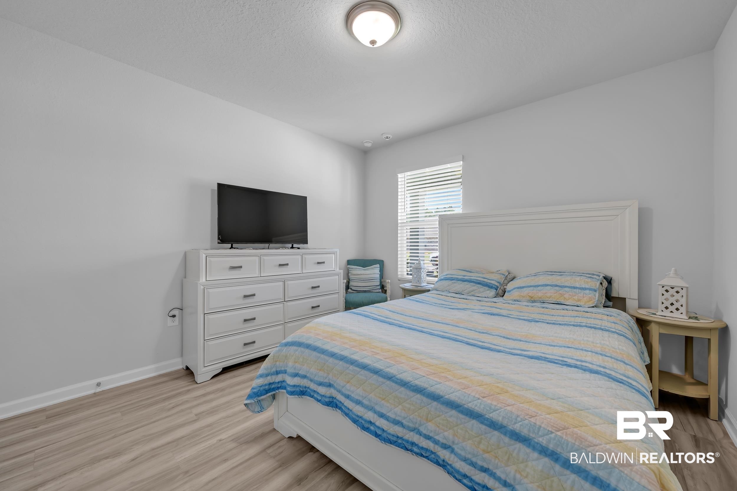 24271 Ringneck Loop Elberta, AL 36530 - Photo 27 of 44 Bright bedroom featuring neutral paint, wood-finish flooring, and a single window with horizontal blinds