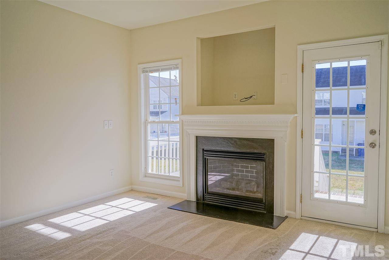 4232 Beacon Crest Way Raleigh, NC 27604 - Photo 5 of 25 a living room with a fireplace and a window