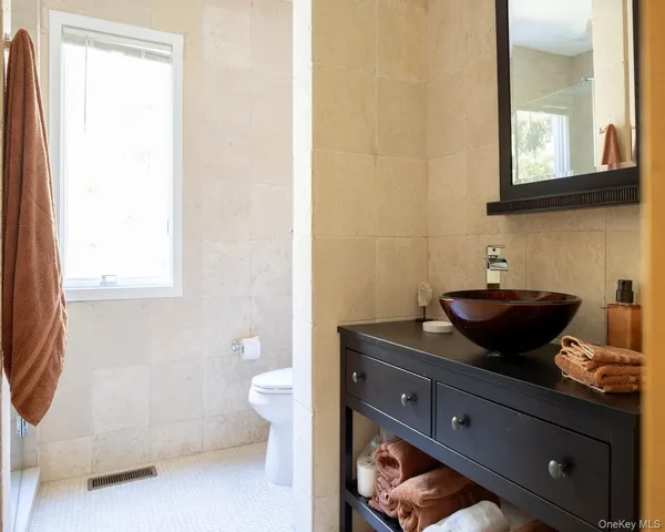 a bathroom with a toilet a sink and mirror