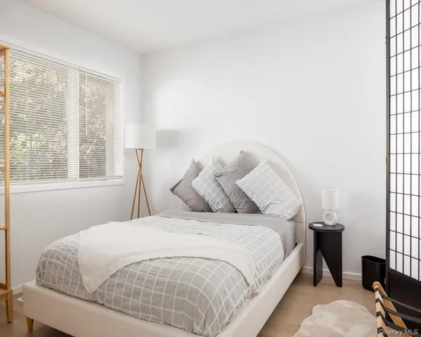 a large bed sitting in a bedroom next to a window