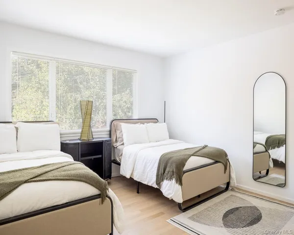 a bedroom with two beds and a large window