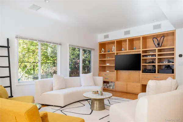 a living room with furniture tv and a large window