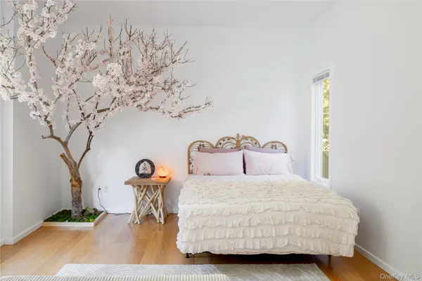 a bedroom with a bed and a table with potted plant