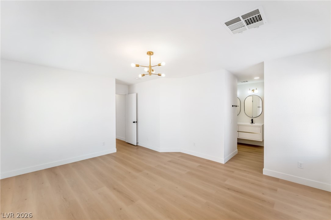 668 Rising Brook Drive Henderson, NV 89011 - Photo 10 of 22 A luminous space with smooth hardwood flooring flows into an adjacent, pristine bathroom vanity area.