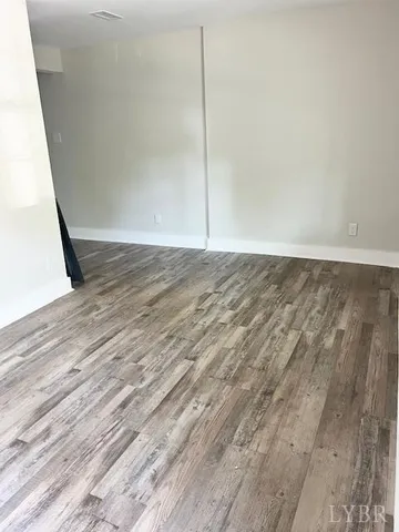 a view of a room with wooden floor