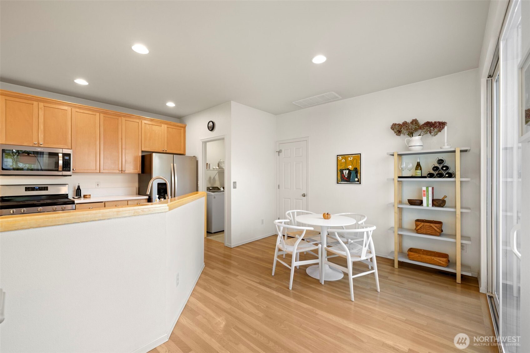 12058 Concord Way Mukilteo, WA 98275 - Photo 13 of 31 a kitchen with stainless steel appliances a refrigerator a stove a dining table and chairs with wooden floor