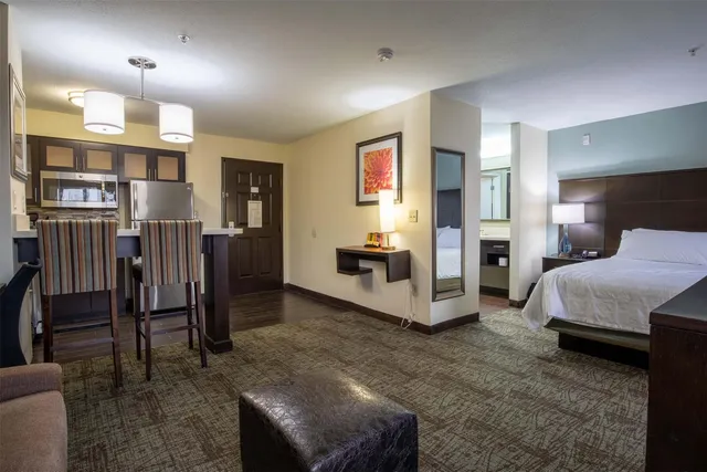 a spacious bedroom with a bed a couch and a view living room